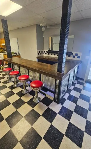 Diner-style bar with red chrome stools and checkerboard floor